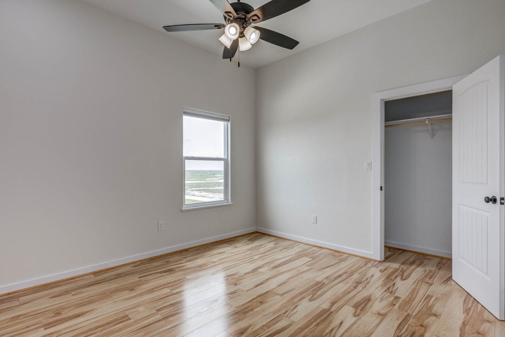 13-14 Bayview Loop Rockport, TX 78382 - Photo 15 of 26 wooden floor in an empty room with a window