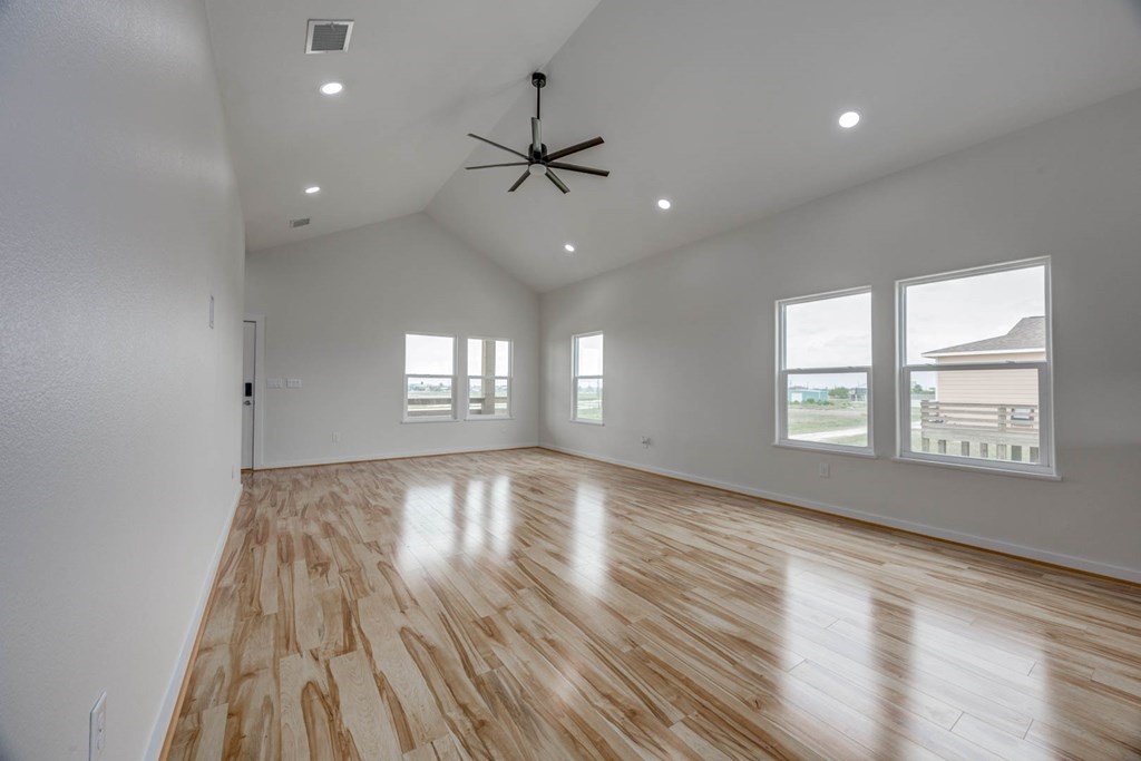 13-14 Bayview Loop Rockport, TX 78382 - Photo 7 of 26 an empty room with wooden floor and windows