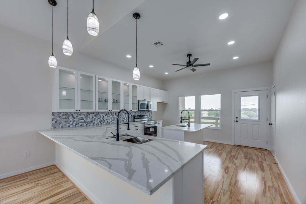 13-14 Bayview Loop Rockport, TX 78382 - Photo 8 of 26 a large kitchen with kitchen island a stove a sink a center island a rug and wooden floor