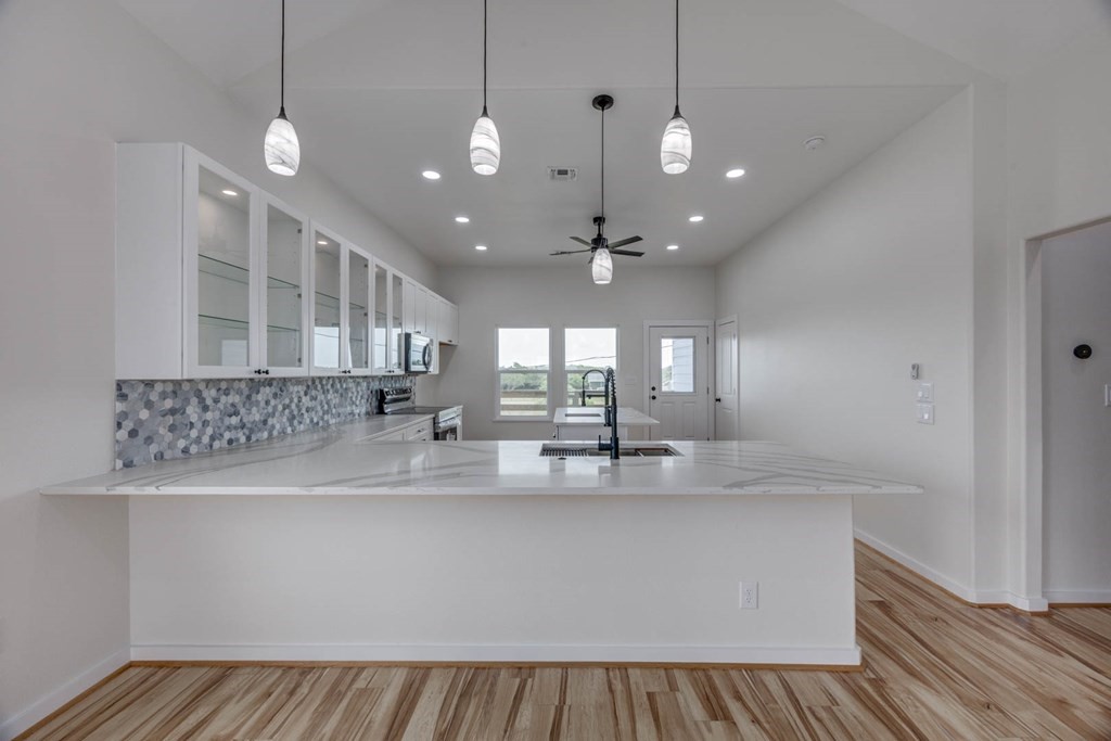 13-14 Bayview Loop Rockport, TX 78382 - Photo 9 of 26 a large kitchen with kitchen island a large counter space a sink and appliances
