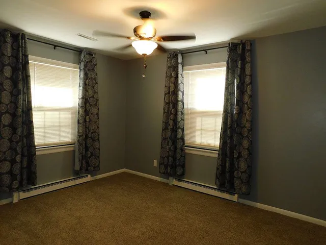 an empty room with windows and closet