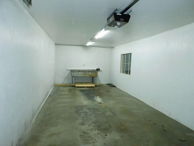 en empty room with ceiling fan and window