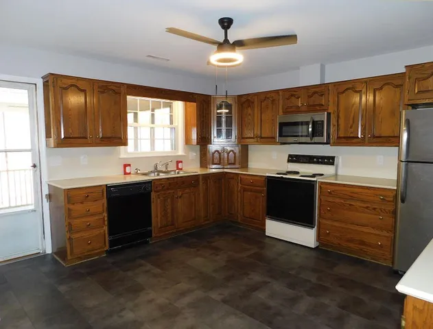 a kitchen with stainless steel appliances granite countertop a stove sink and microwave
