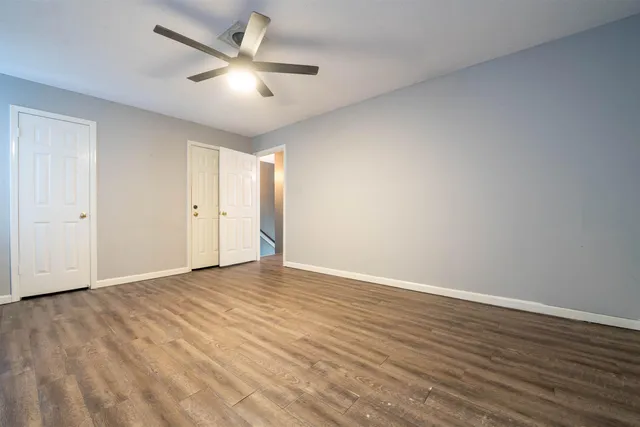 a view of an empty room with wooden floor