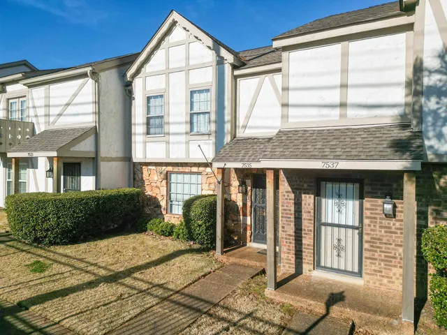 a view of a brick house with many windows