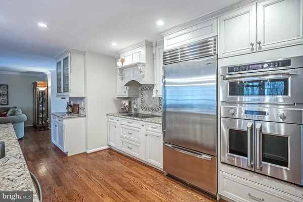 a kitchen with stainless steel appliances kitchen island granite countertop a refrigerator and cabinets