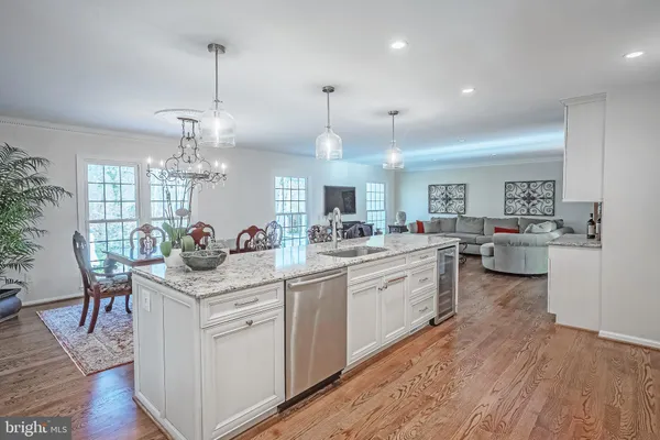 a large kitchen with kitchen island a sink a stove a dining table and chairs