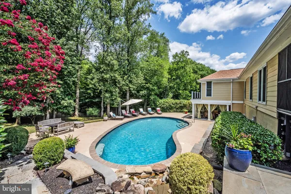 a view of a swimming pool with back yard of the house