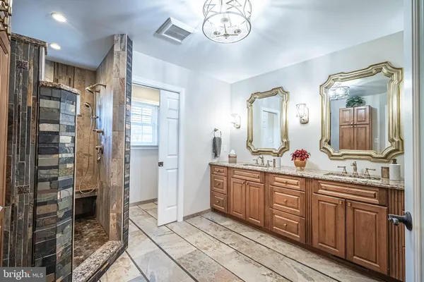 a spacious bathroom with a double vanity sink a mirror and a shower