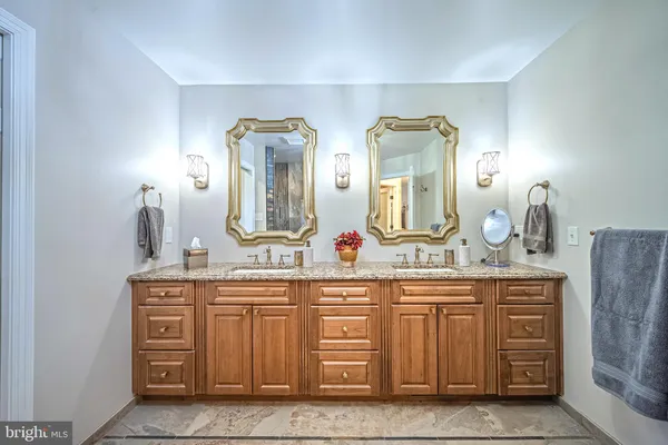 a bathroom with a granite countertop double vanity sink and a mirror