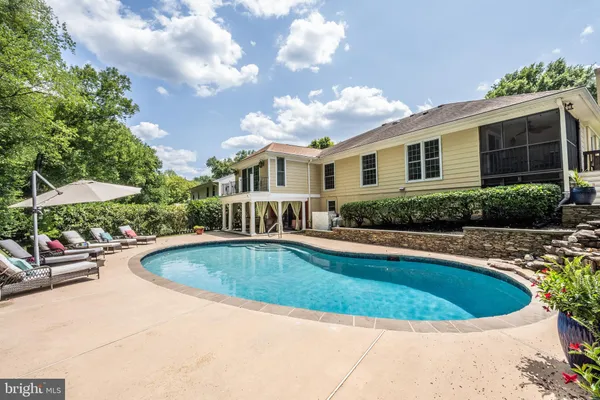a view of a white house with a swimming pool and sitting area