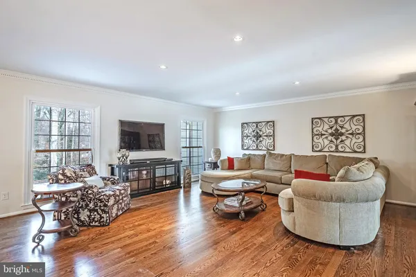 a living room with furniture and a flat screen tv with wooden floor