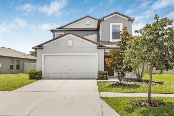 a front view of a house with a yard and garage