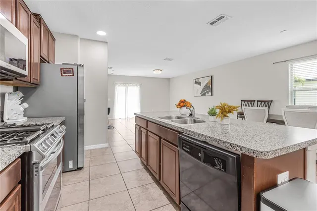 a kitchen with stainless steel appliances granite countertop a sink stove and refrigerator