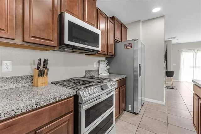 a kitchen with stainless steel appliances granite countertop a stove microwave and refrigerator