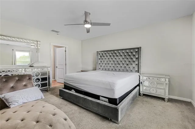 a spacious bedroom with a bed and a chandelier
