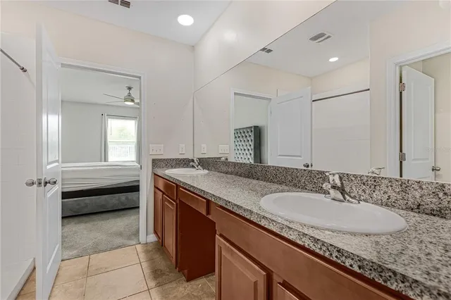 a bathroom with a granite countertop sink a mirror and a bathtub