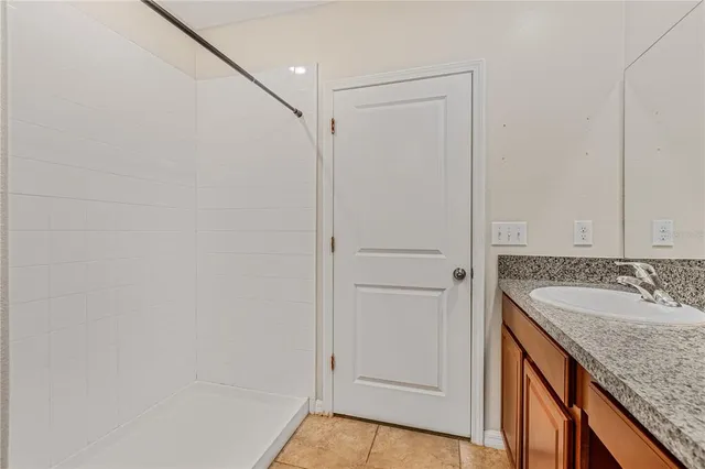 a bathroom with a granite countertop sink and a mirror