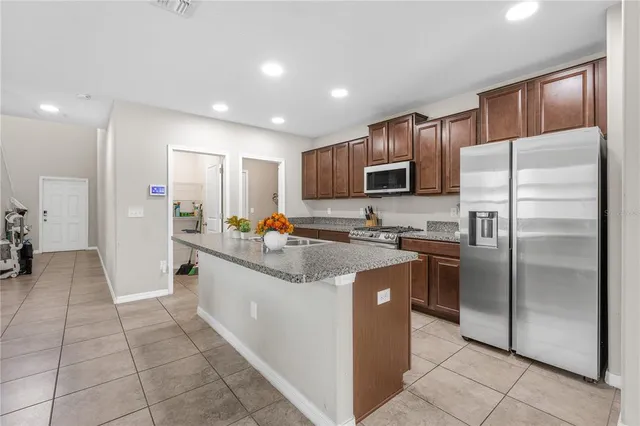 a kitchen with stainless steel appliances granite countertop a refrigerator and a stove