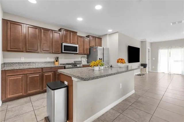 a kitchen with stainless steel appliances granite countertop a sink stove and microwave