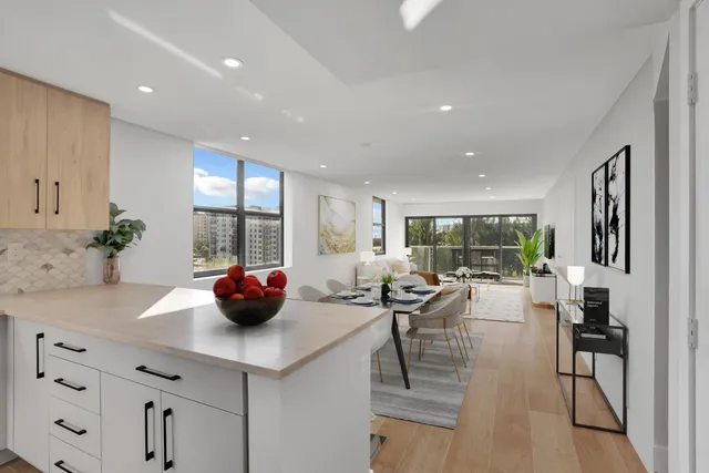a view of kitchen with stainless steel appliances dining table chairs and white cabinets