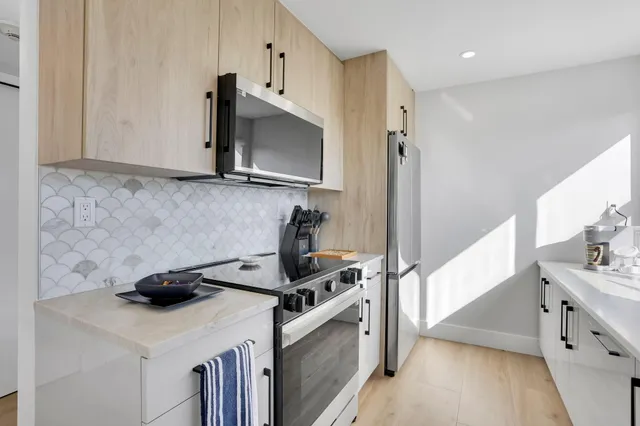 a kitchen with a sink and a stove top oven with wooden floor