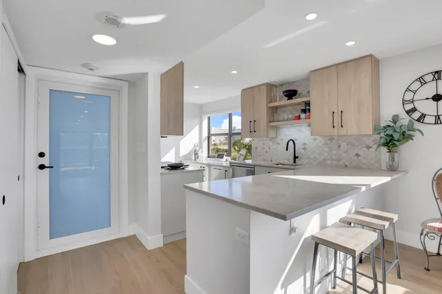 a kitchen with stainless steel appliances granite countertop a sink and a refrigerator