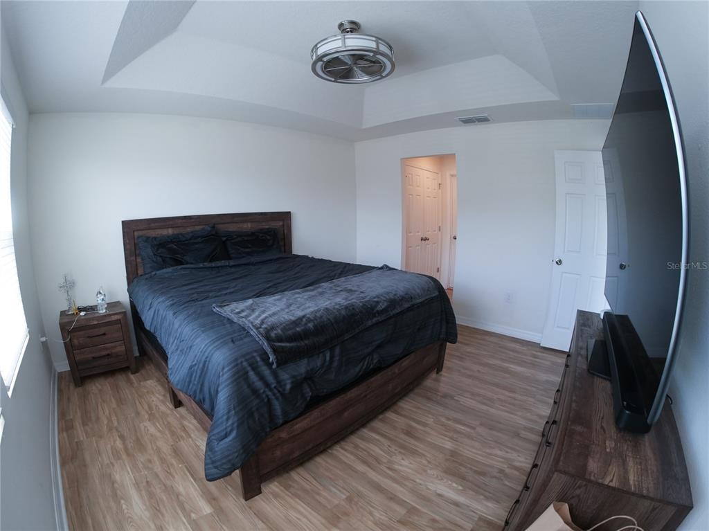 2451 Varenna Loop Kissimmee, FL 34741 - Photo 10 of 11 a bedroom with a bed and wooden floor