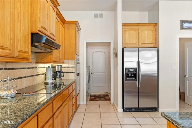 a large kitchen with granite countertop a sink and a large window