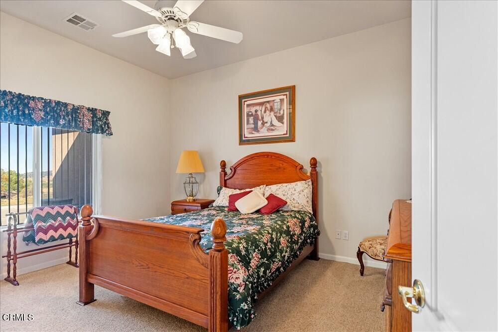 26450 Cumberland Road Tehachapi, CA 93561 - Photo 30 of 52 a bedroom with a bed and a chandelier