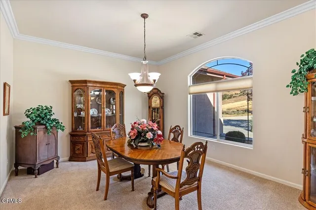 a view of a dining room with furniture and chandelier