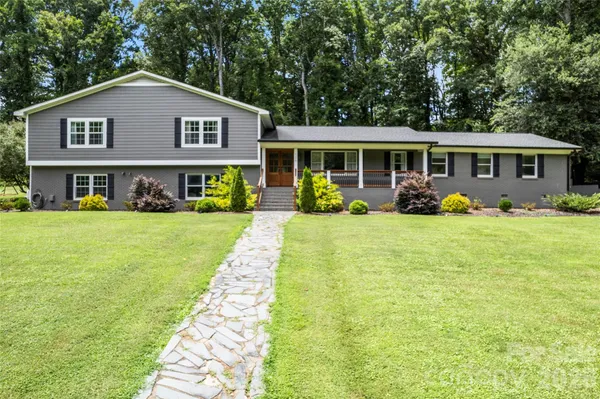 a front view of a house with yard and green space