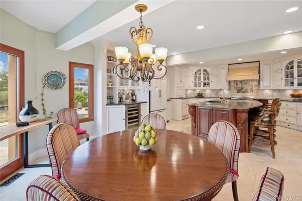 a dining room filled chandelier and wooden floor