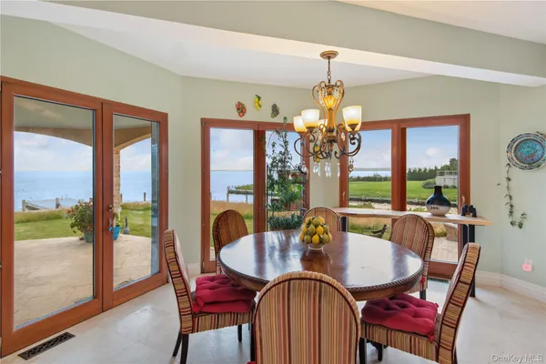 a dining room with furniture a chandelier and large windows