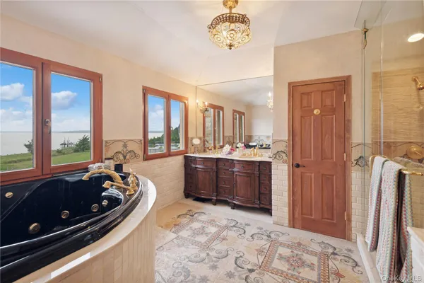 a spacious bathroom with a tub a sink and a large mirror
