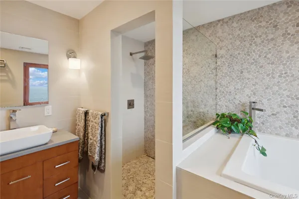 a bathroom with a granite countertop sink a mirror and shower
