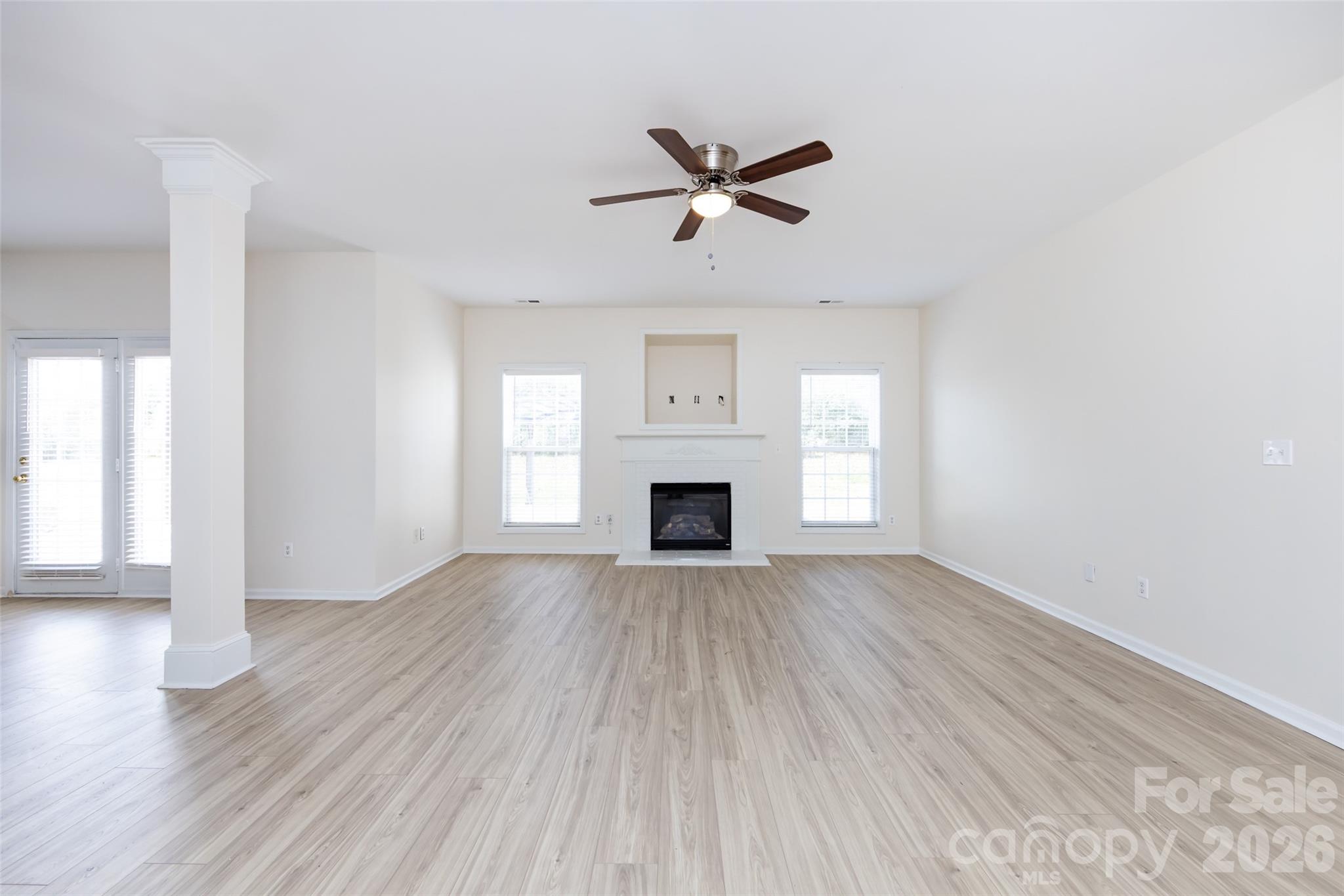 2705 Gosling Terrace Road Charlotte, NC 28262 - Photo 16 of 36 an empty room with wooden floor fireplace and windows