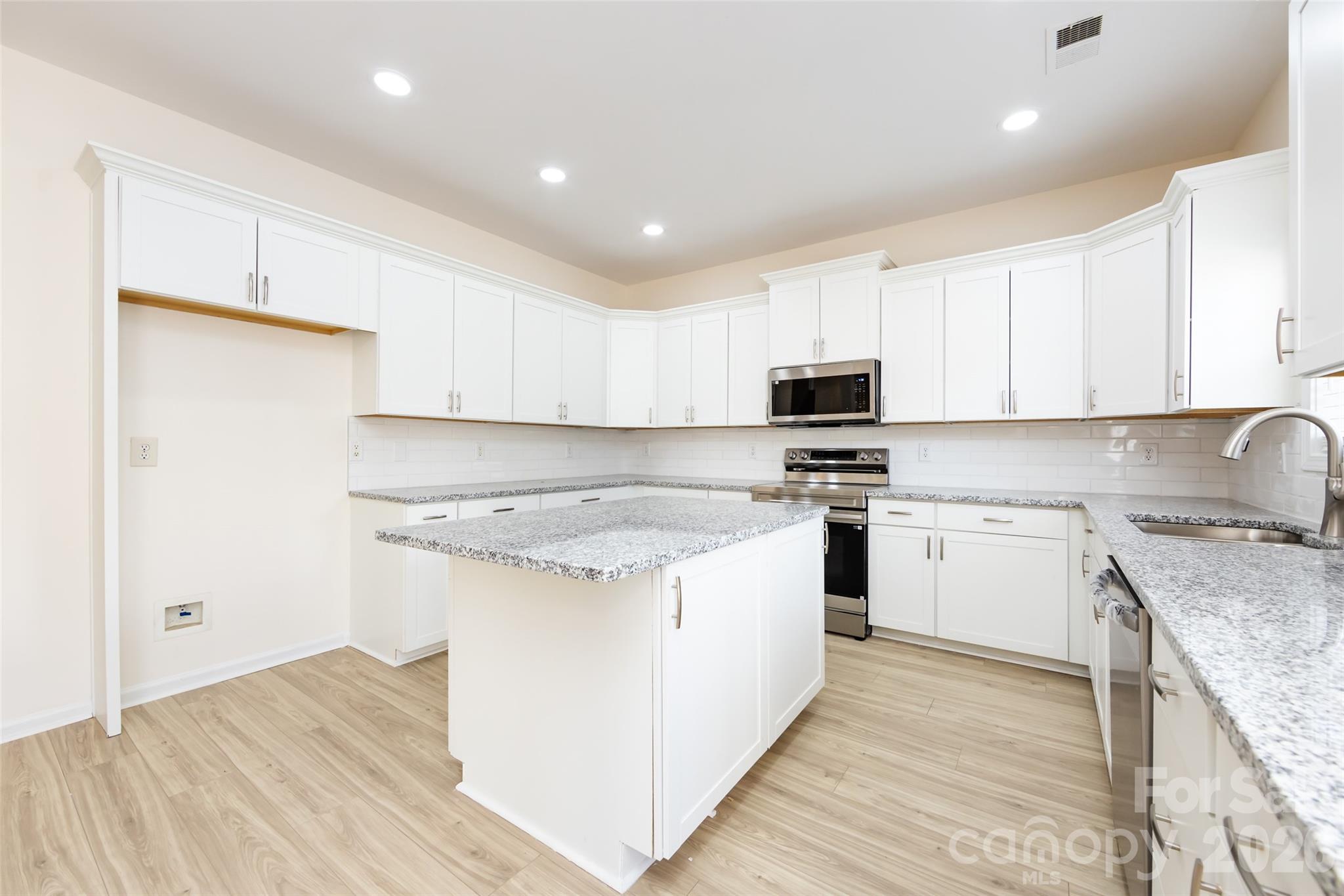 2705 Gosling Terrace Road Charlotte, NC 28262 - Photo 22 of 36 a kitchen with granite countertop white cabinets and white appliances