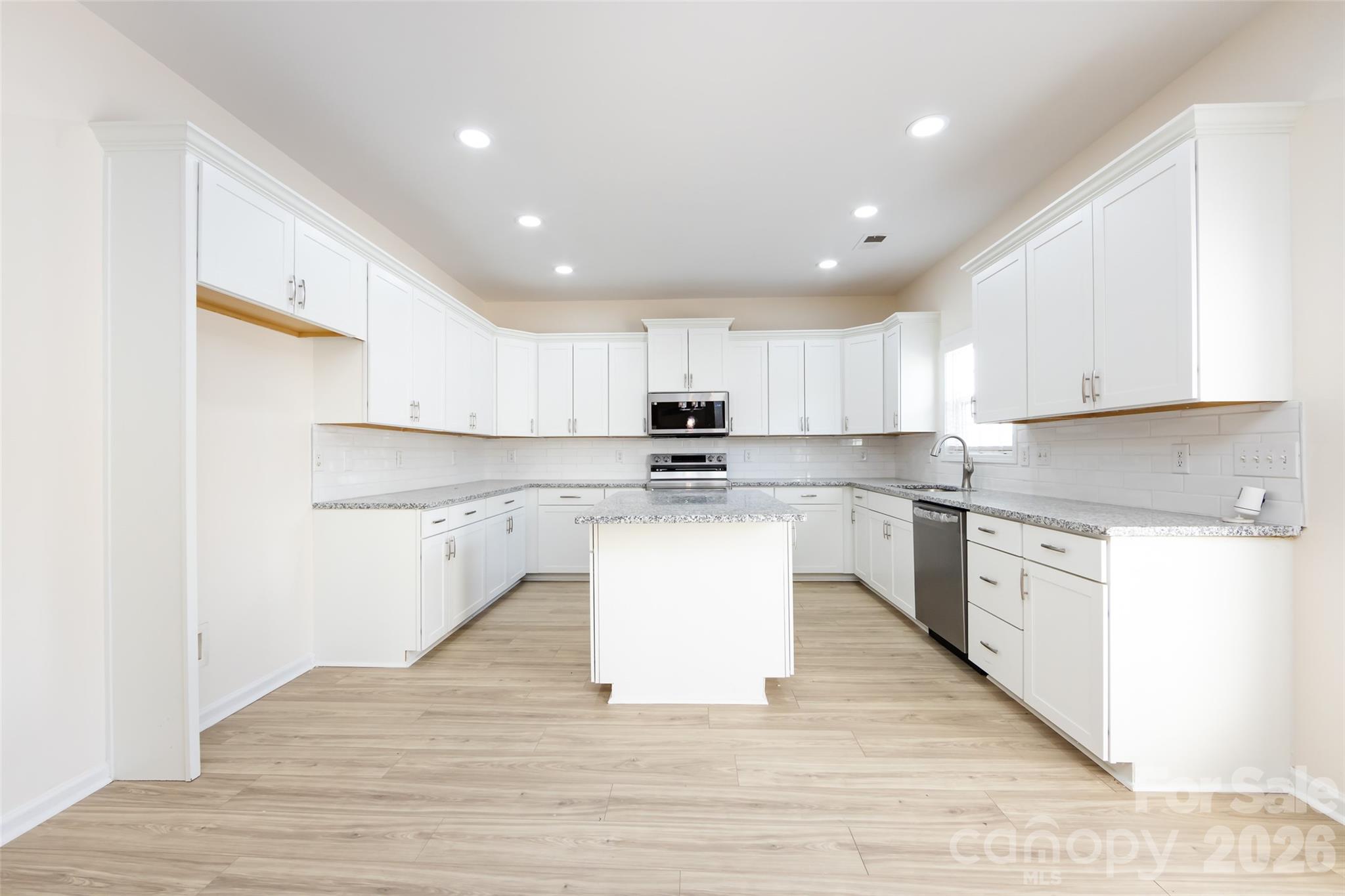 2705 Gosling Terrace Road Charlotte, NC 28262 - Photo 24 of 36 a large kitchen with kitchen island a sink a stove a center island and a window