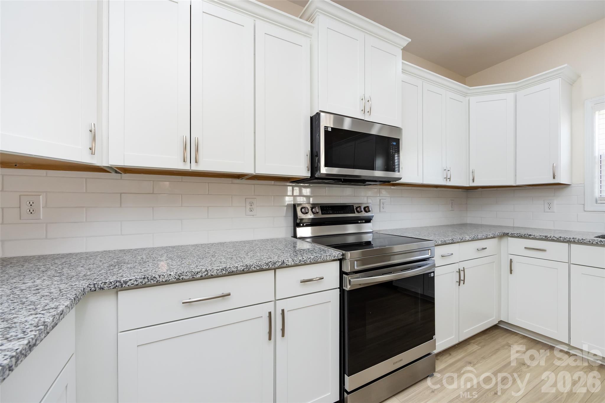 2705 Gosling Terrace Road Charlotte, NC 28262 - Photo 26 of 36 a kitchen with granite countertop white cabinets and stainless steel appliances