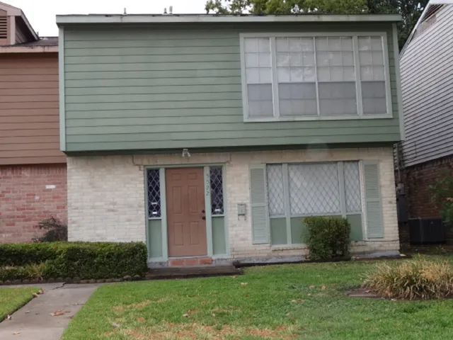a view of a backyard with a fence and a large tree