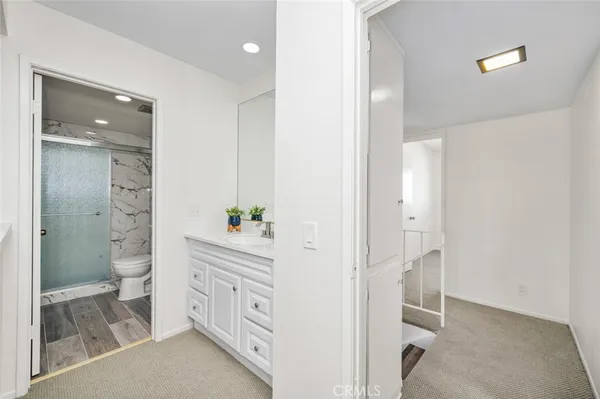 a spacious bathroom with a double vanity sink a toilet and a mirror