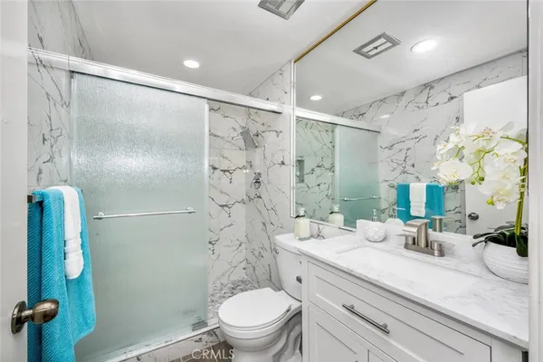 a bathroom with a sink a toilet a shower and a mirror