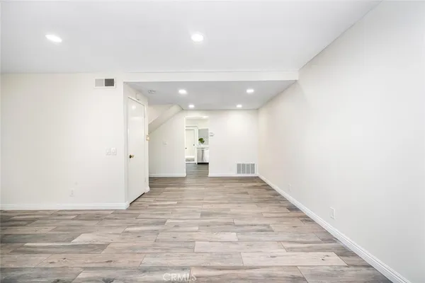 a view of a big room with wooden floor and windows