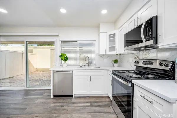 a kitchen with stainless steel appliances a stove sink microwave and cabinets