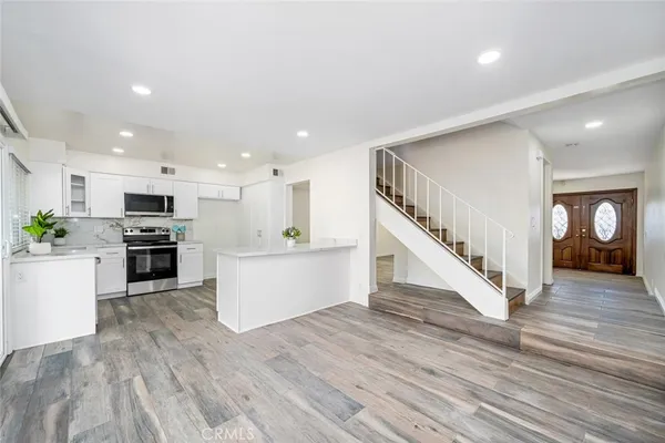 a view of kitchen with wooden floor and electronic appliances