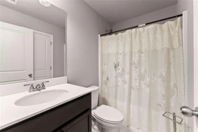 a bathroom with a sink a toilet and shower curtain