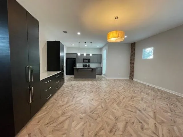 a kitchen with stainless steel appliances granite countertop a sink a stove a microwave and a refrigerator