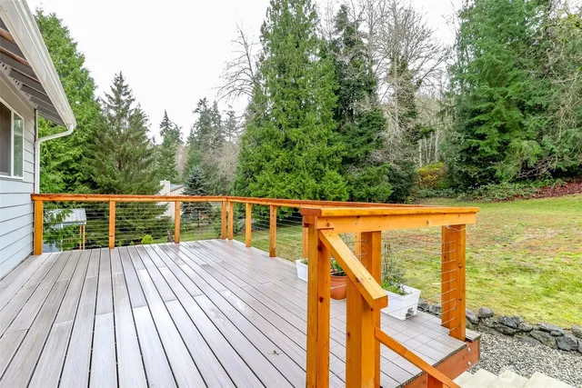 a view of a house with a wooden deck and a patio