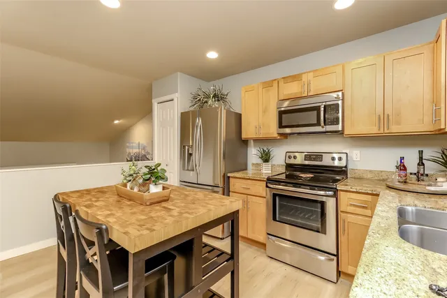 a kitchen with kitchen island granite countertop wooden floors and white cabinets